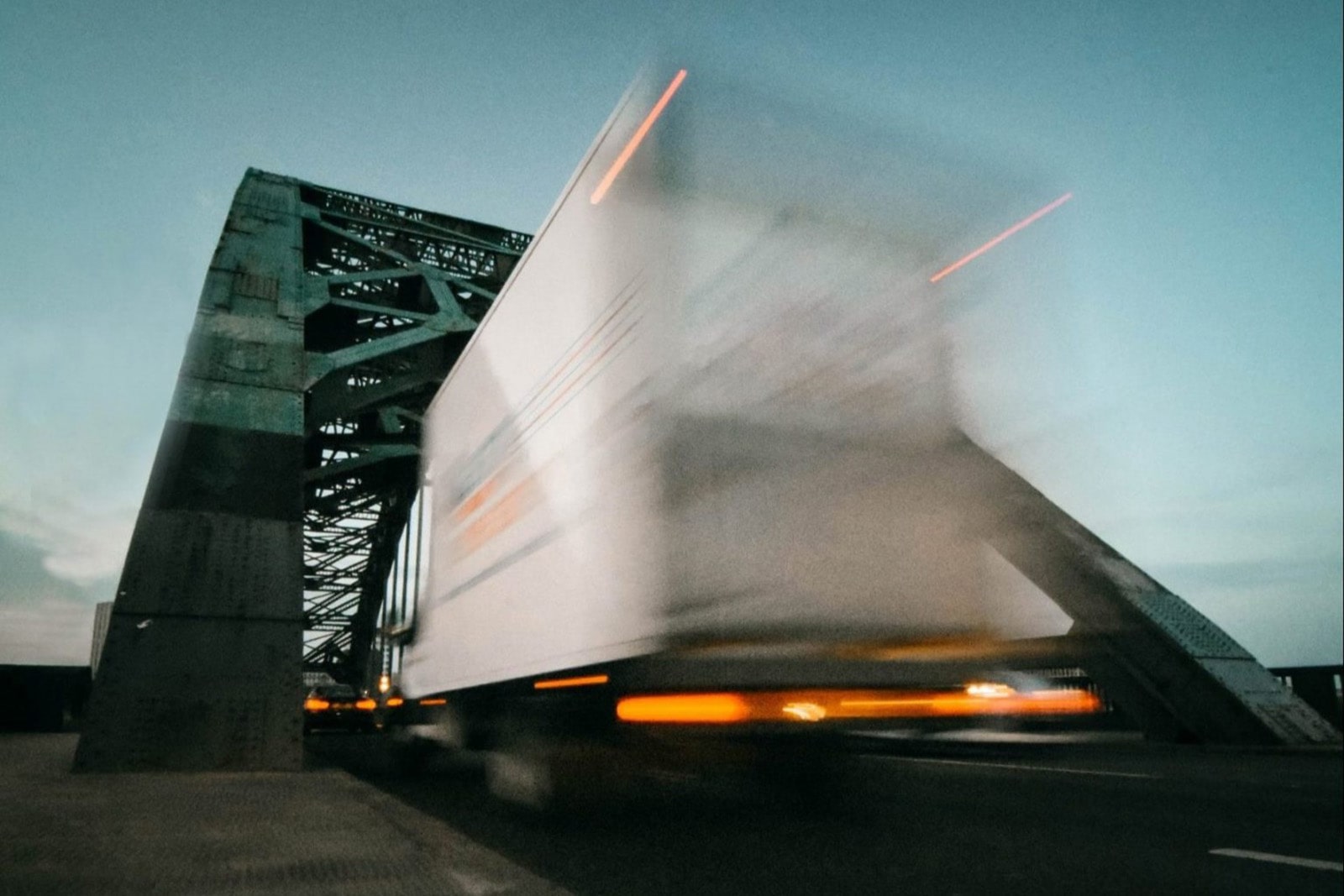 A heavy goods vehicle passing over a truss bridge