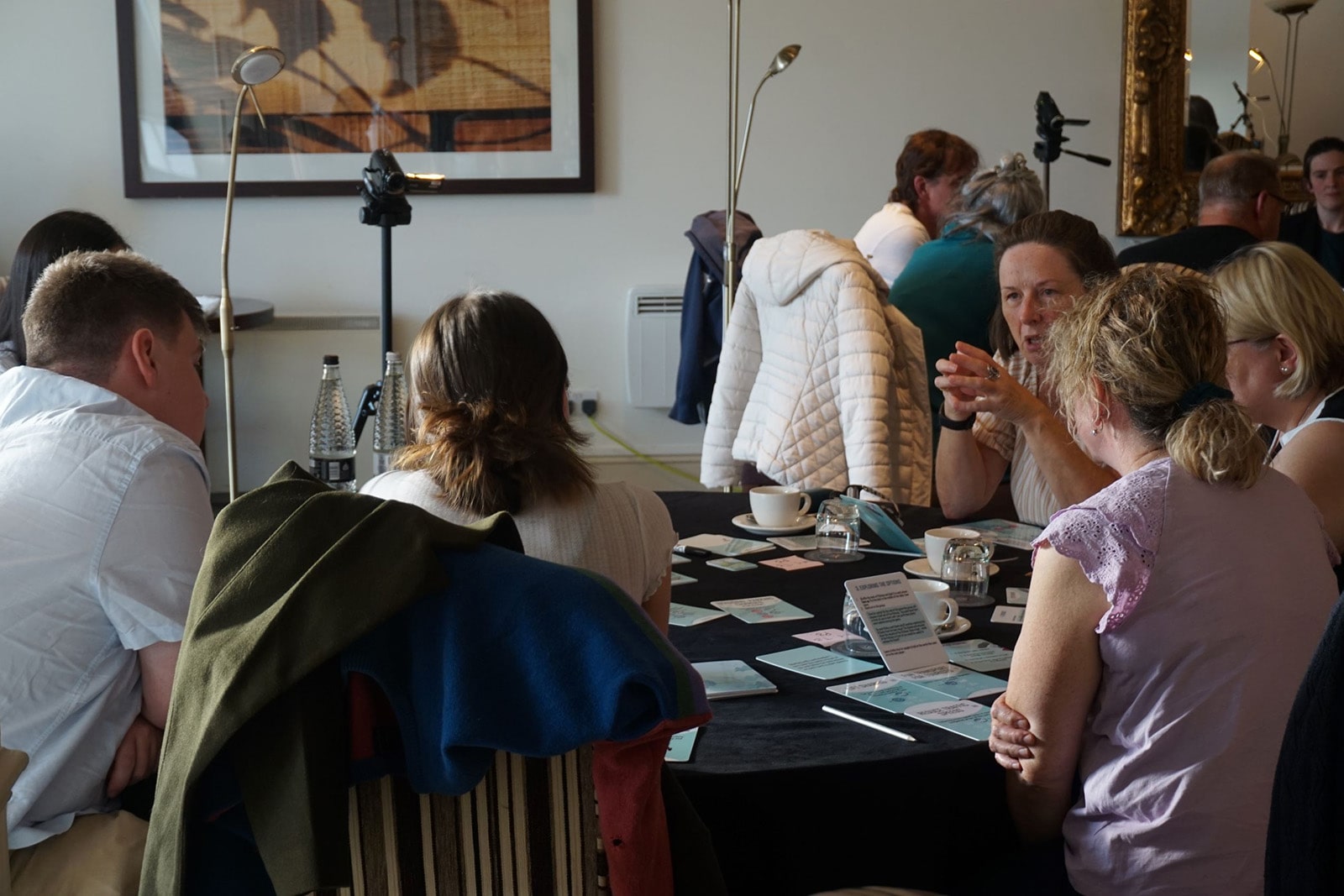 Members of the local community gather round a table take part in an alternative approach to conventional citizen consultations