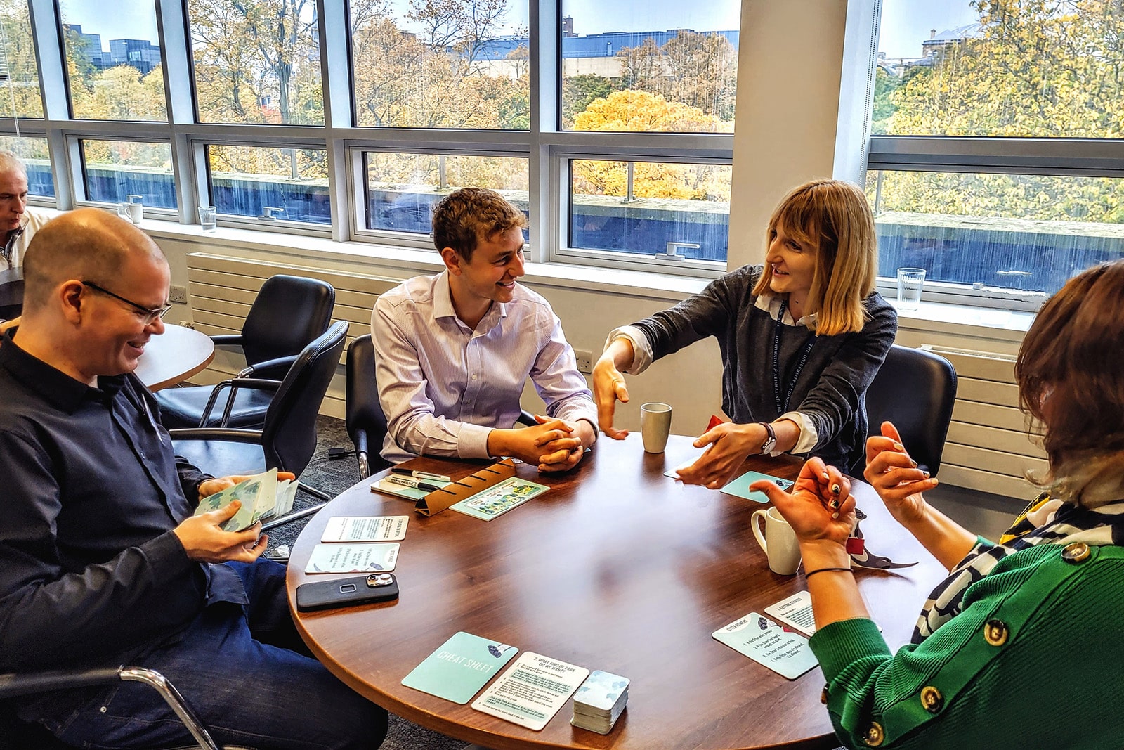 A small group of practitioners sit at a table while taking part in a game designed to facilitate discussion around sustainable transport