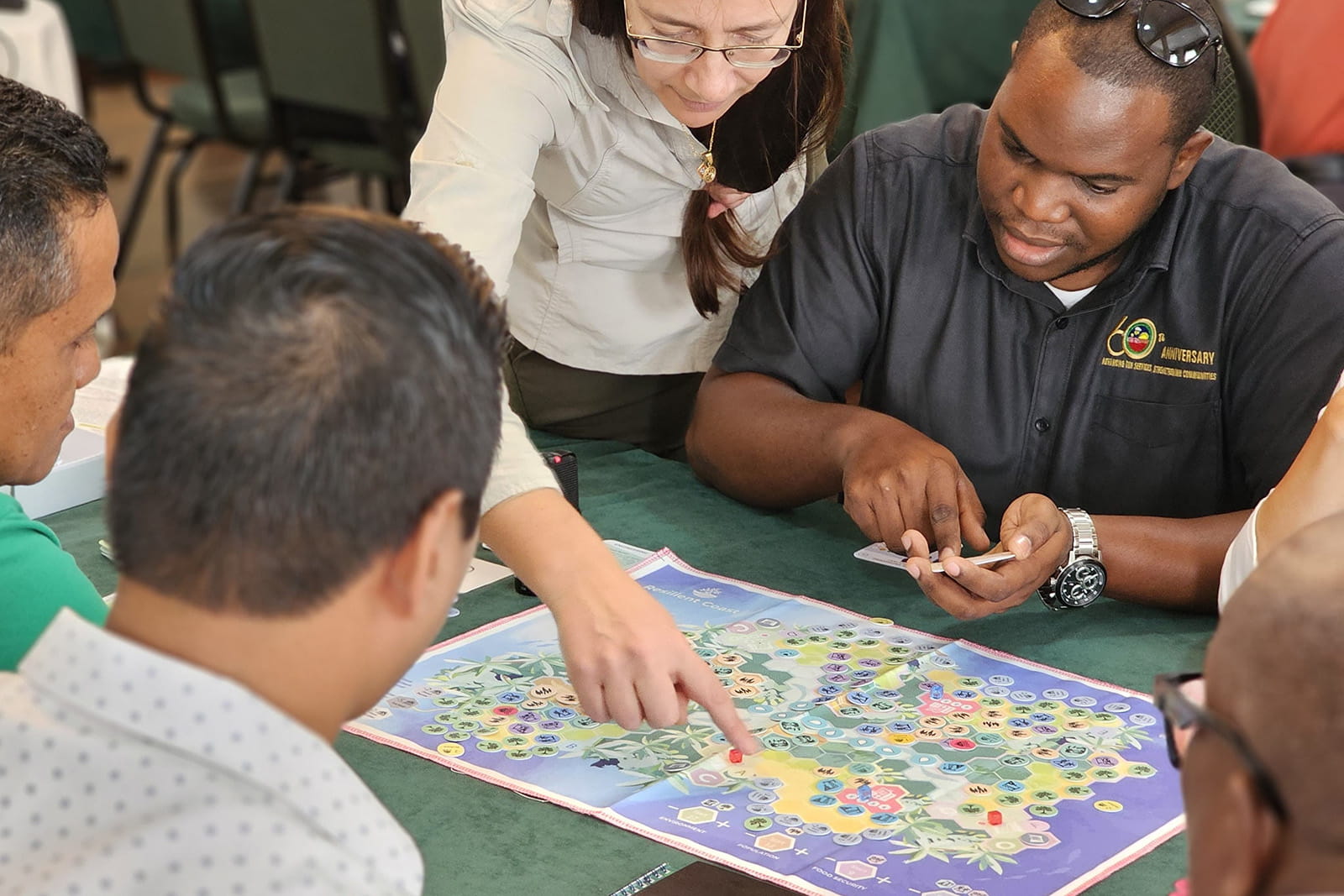 A diverse group of people gathered around a table, engaged in a lively board game session.