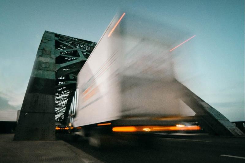 A heavy goods vehicle passing over a truss bridge